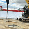 Ground Screws the Future of Infrastructure Development illustrated in a construction site with a crane and a machine.